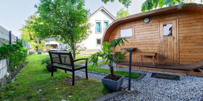 Ein Highlight im Garten: Die formschöne Außensauna bietet Wellness pur – direkt vor der Haustür.