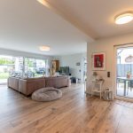 Wohnbereich mit Kamin und mehreren Zugängen zum liebevoll angelegten Garten